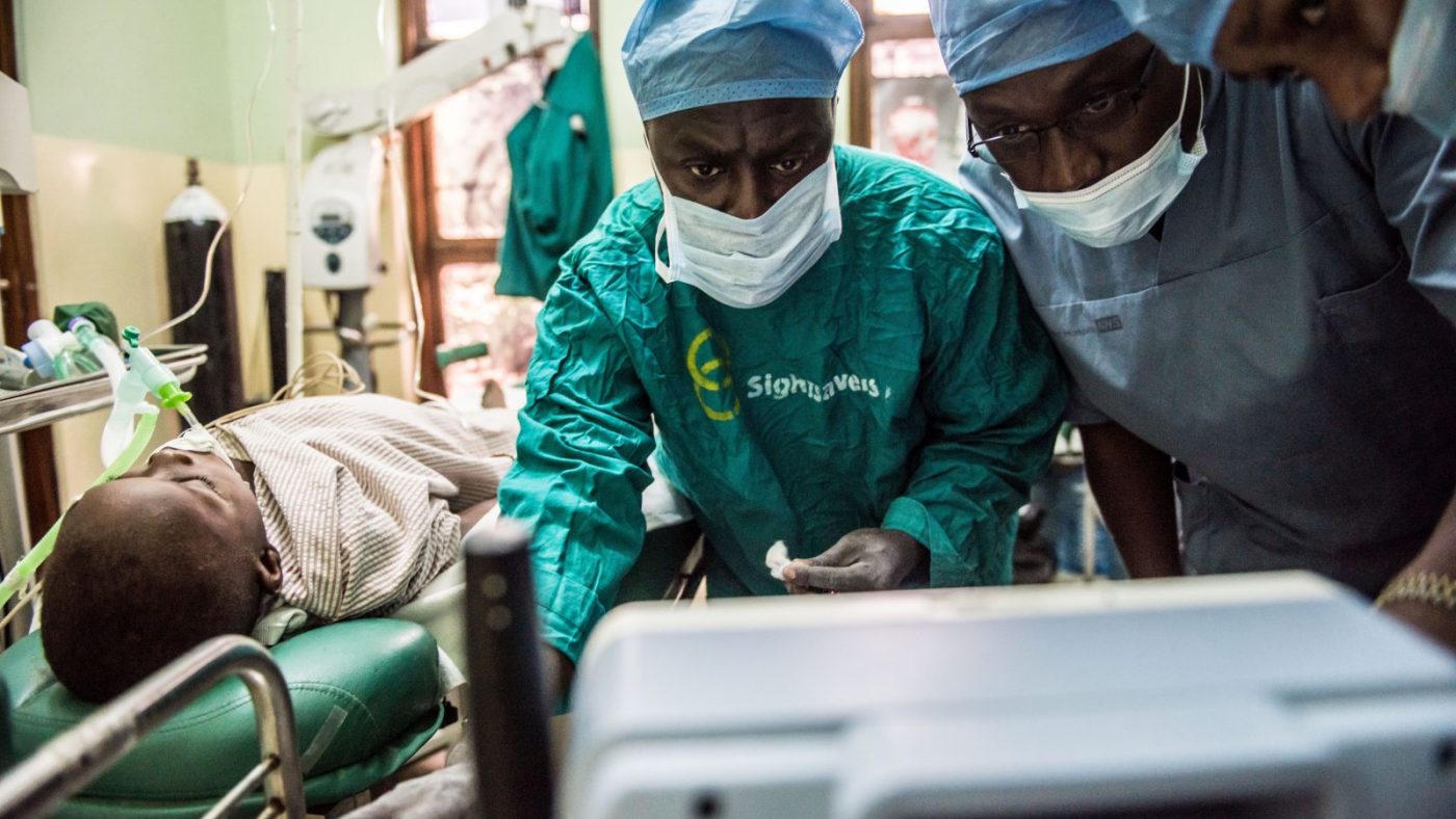 A group of surgeons look at a screen.