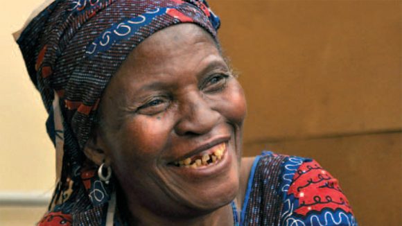 From the cover of Sightsavers annual report 2010: a woman in a headscarf smiling broadly.