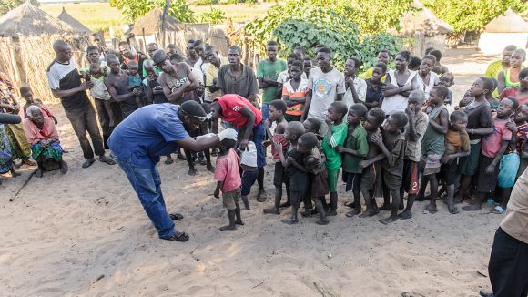 Dr Ndalela is shown screening a queue of young children for trachoma, in Zambia.