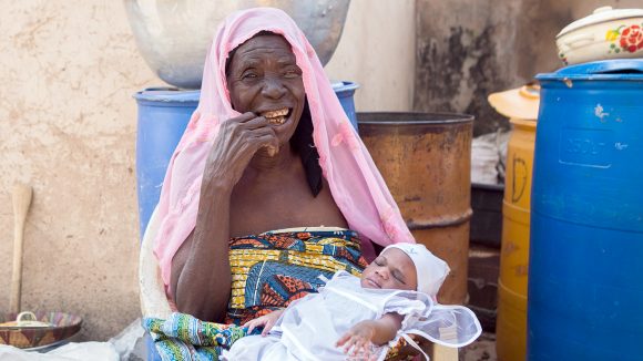 Rahinatu holds her granddaughter and smiles following her trachoma surgery.