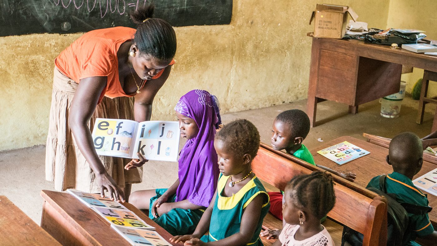 Teach Hassanatu helps pupils in the classroom.