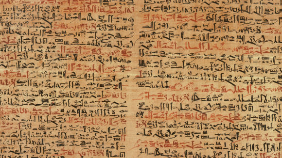 An ancient Egyptian papyrus, showing writing in red and black ink.