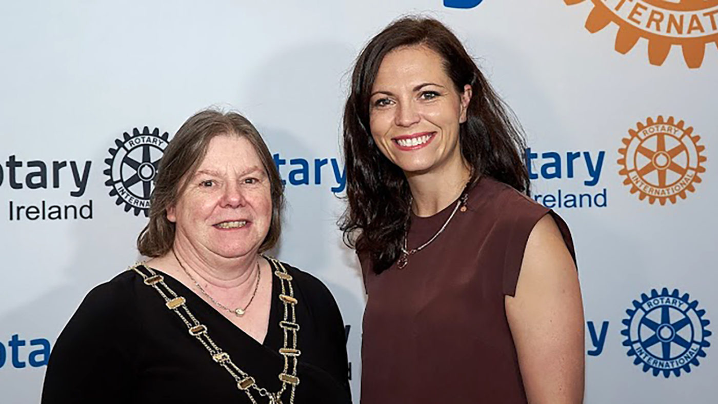 Monica Robertson and Ciara Smullen in front of a backdrop showing Rotary Ireland logos.