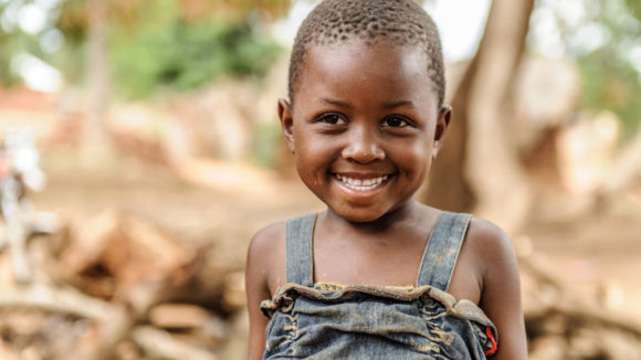 Filly, a little girl from Tanzania smiles at the camera. She has trachoma.