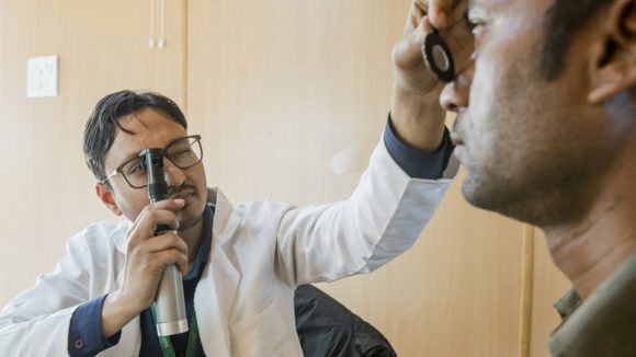Optometrist Mohammed checks a patient's eyes.