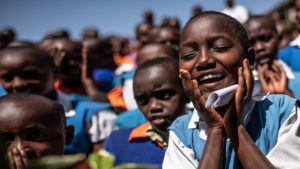 Peace, a student, sings a song that helps her remember how to wash her hands and face