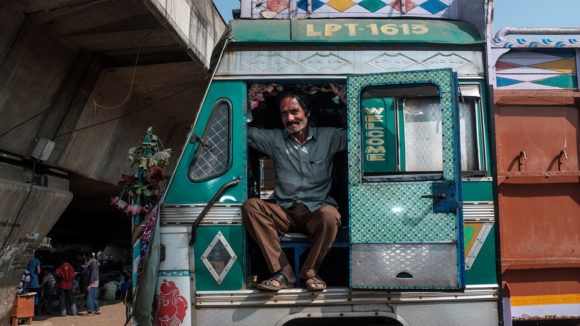 A truck driver sits in his truck.