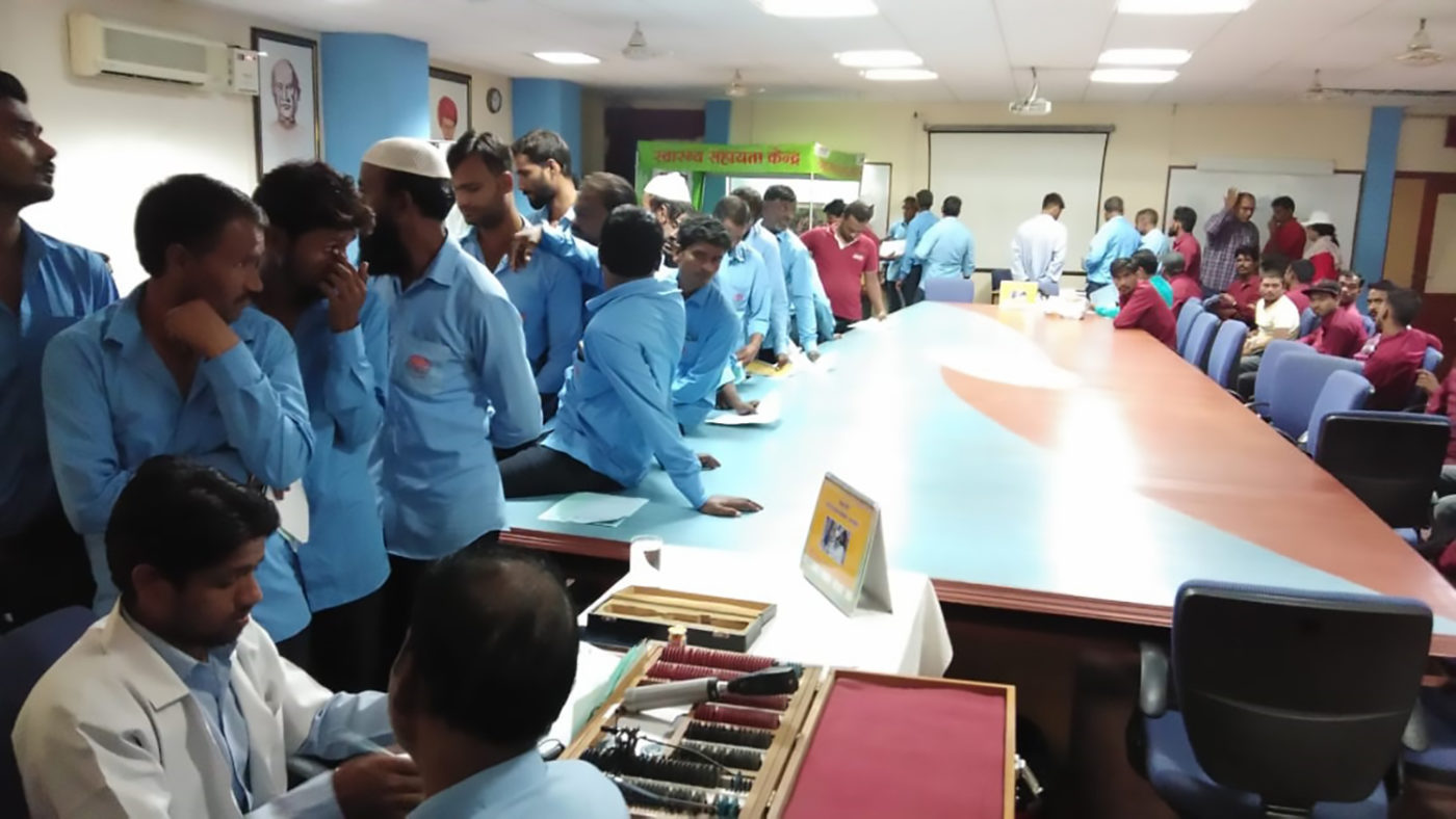 Men queue to have their eyes tested.