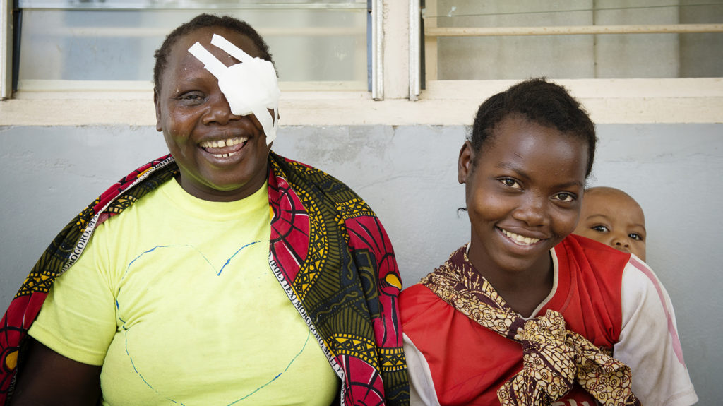 A woman with a bandaged eye and a girl smiling