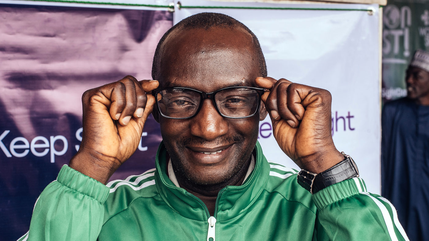A man wearing glasses, smiling.