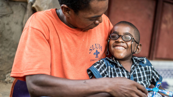 Saidi from Zanzibar smiles with his family member after his cataract operation.