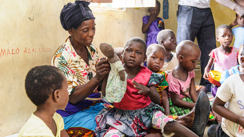 A young girl sits on her grandmother's lap.