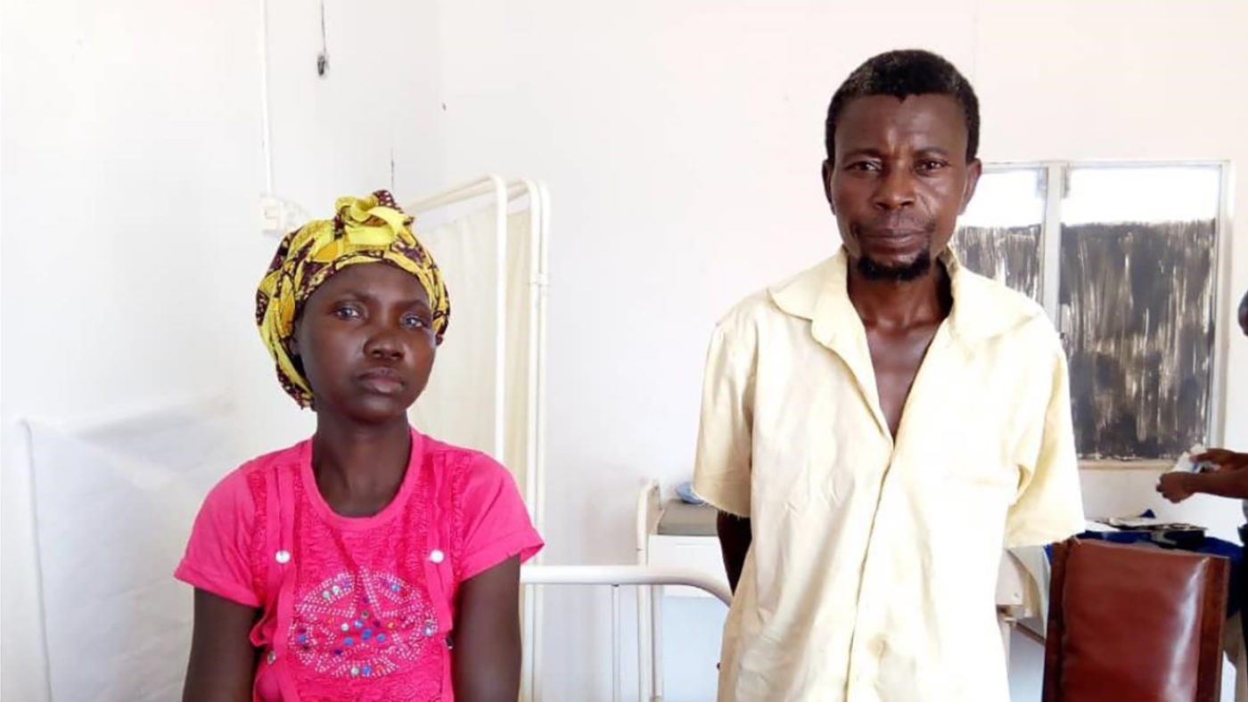 A man and woman wait in a waiting room.