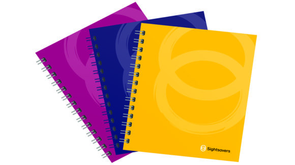 Sightsavers-branded notebooks in yellow, blueberry and raspberry colours.