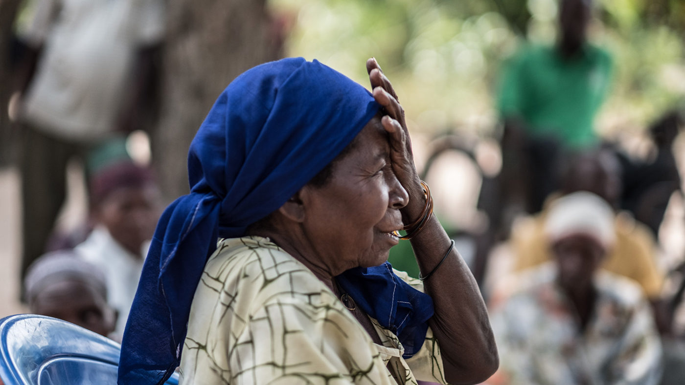 Aziza holds one hand over her eye as she has her eyes checked.