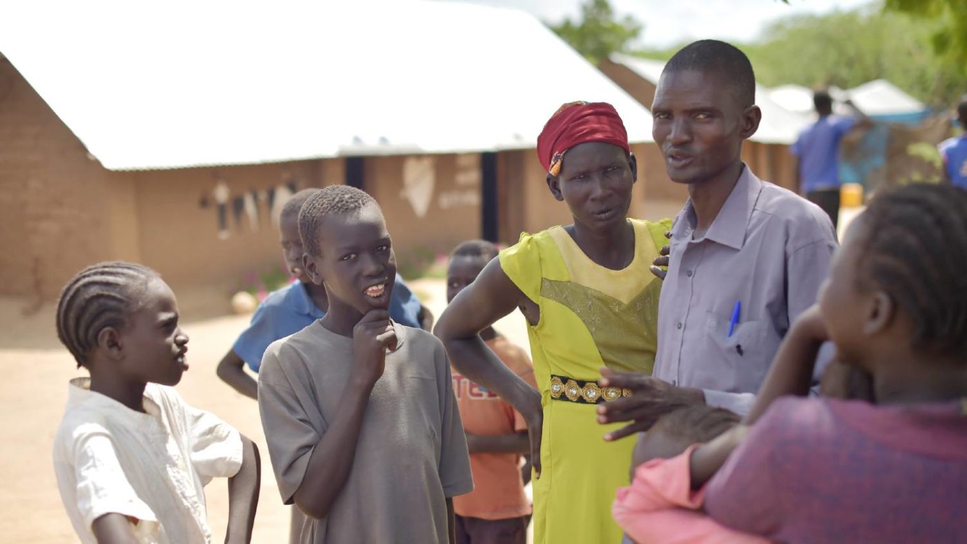 A man talks with community members.