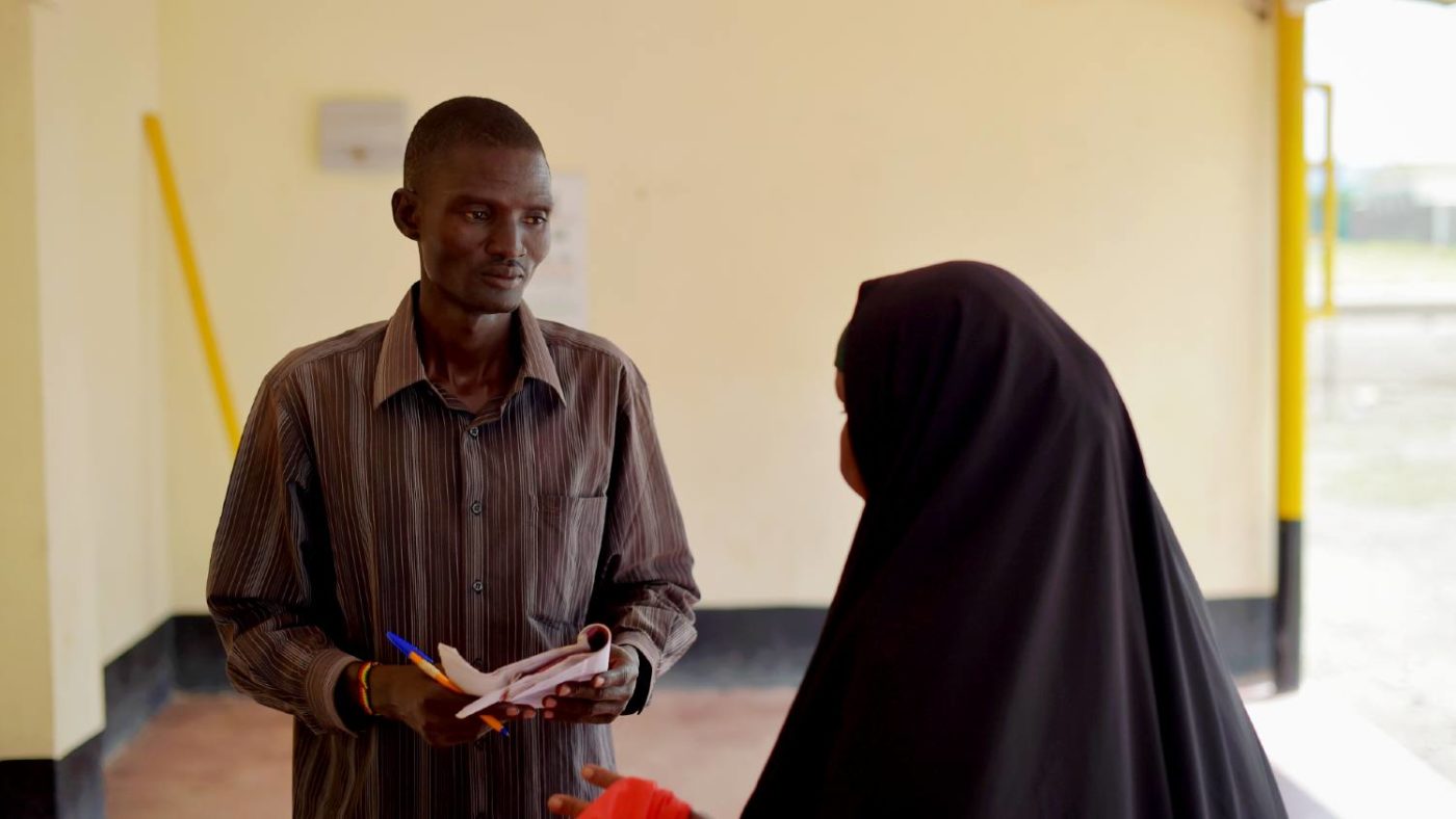 A man speaks to a woman.