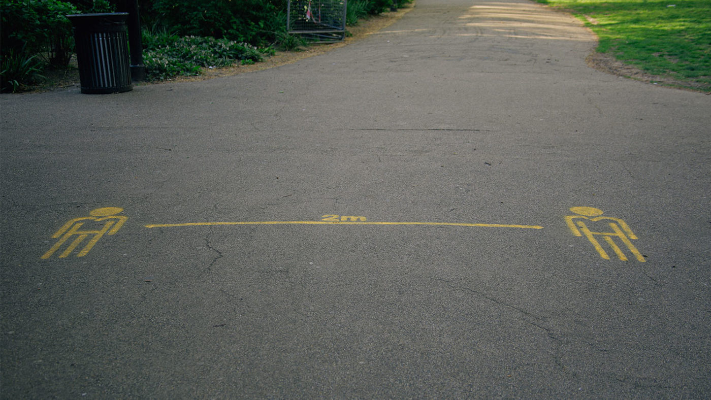 A floor marking on a concrete path showing a two-metre gap.