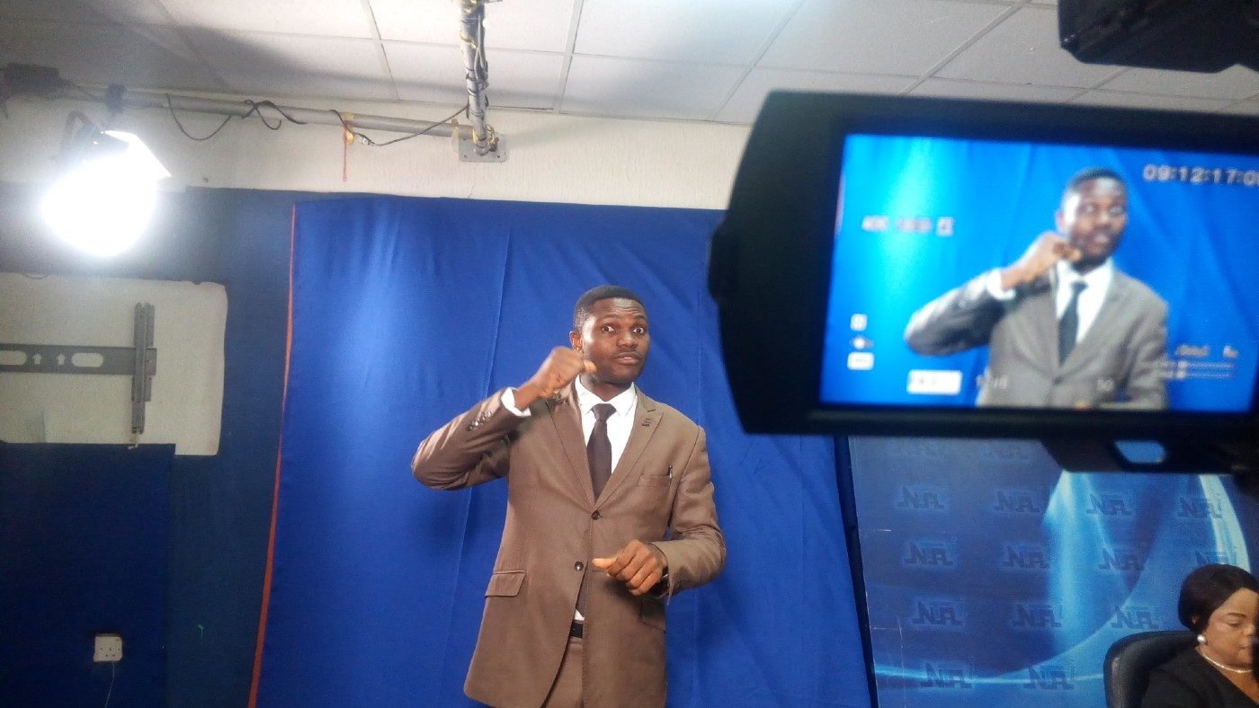 A sign language interpreter in a TV studio.