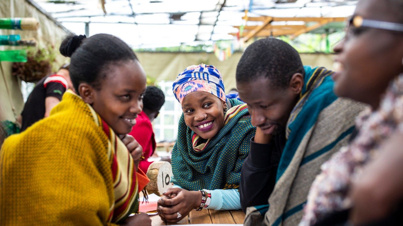 A group of people sit around a table, talking together.