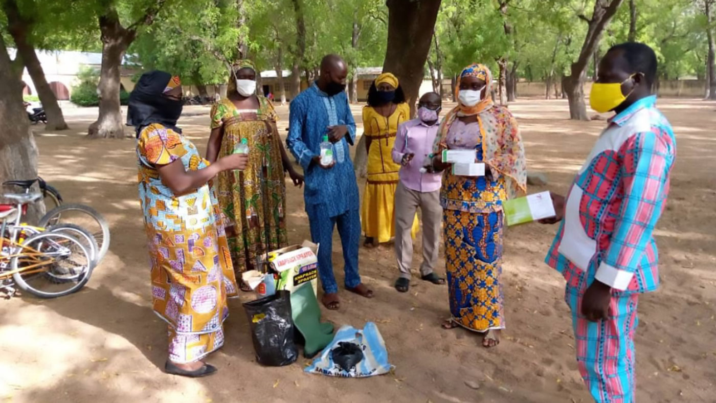 A group of adults hold boxes of hygiene supplies.