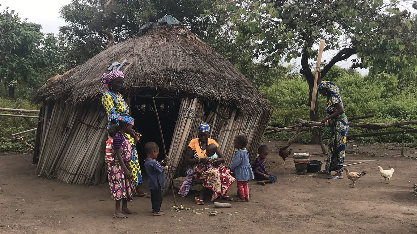 A group of women and children are shown outside their homes.
