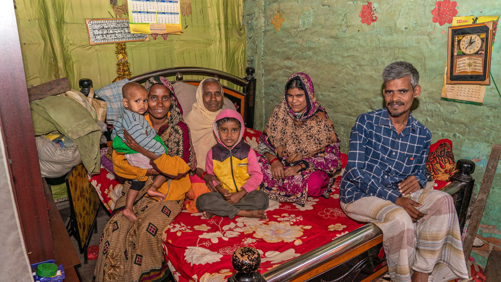 A family sat on a bed.
