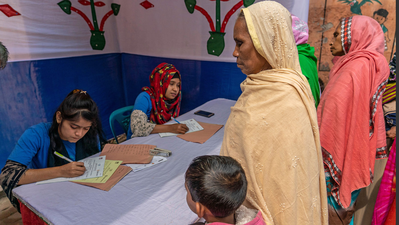 A woman with a child at a registration desk.