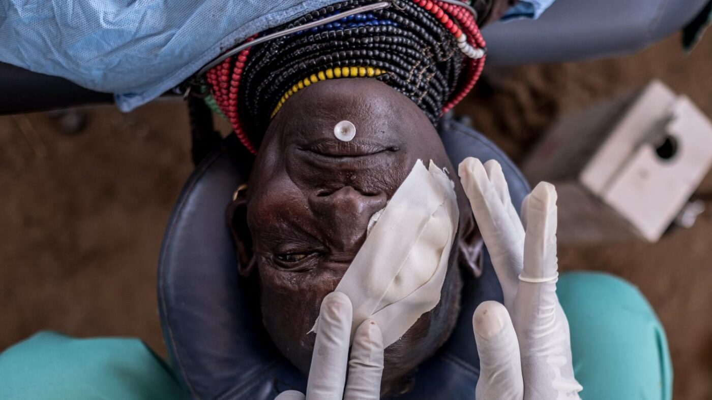 Bandages are applied to a patient wearing traditional clothing on an operating table after a successful trachoma operation