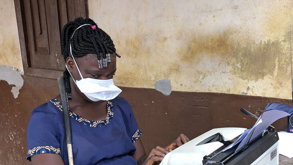 A girl typing on a typewriter.