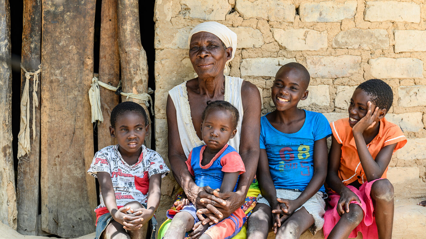 A woman sits with her four grandchildren.