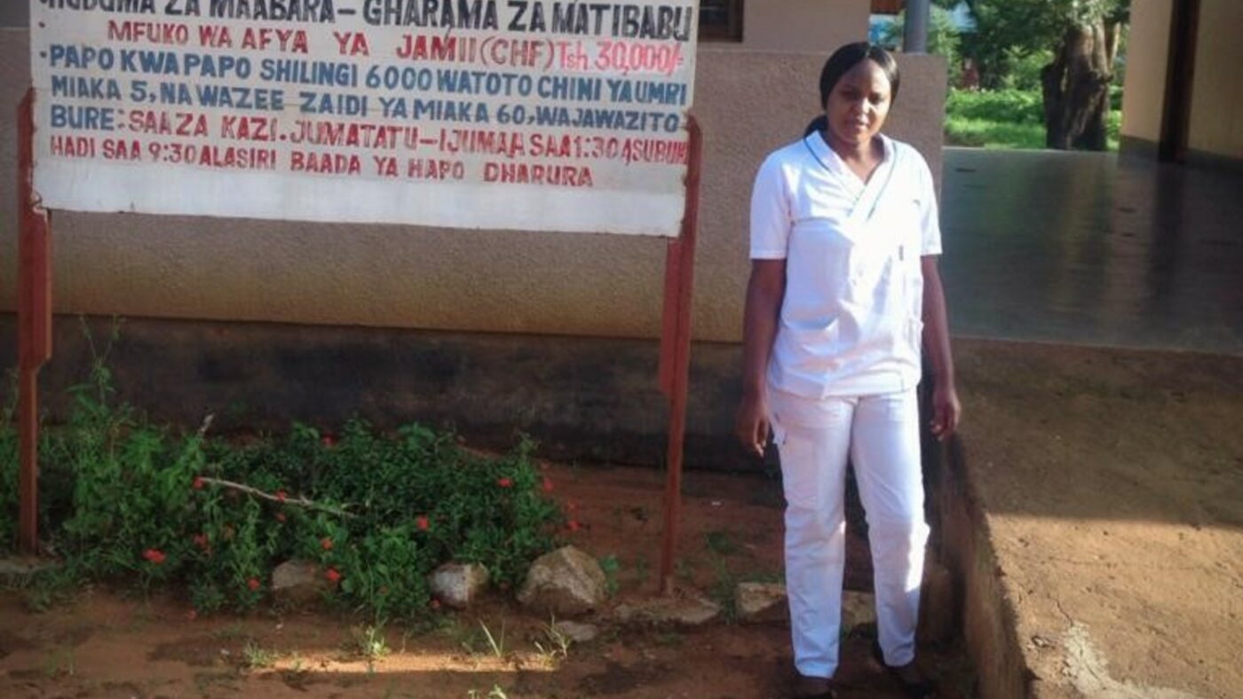 A nurse stands outside a hospital in Tanzania.