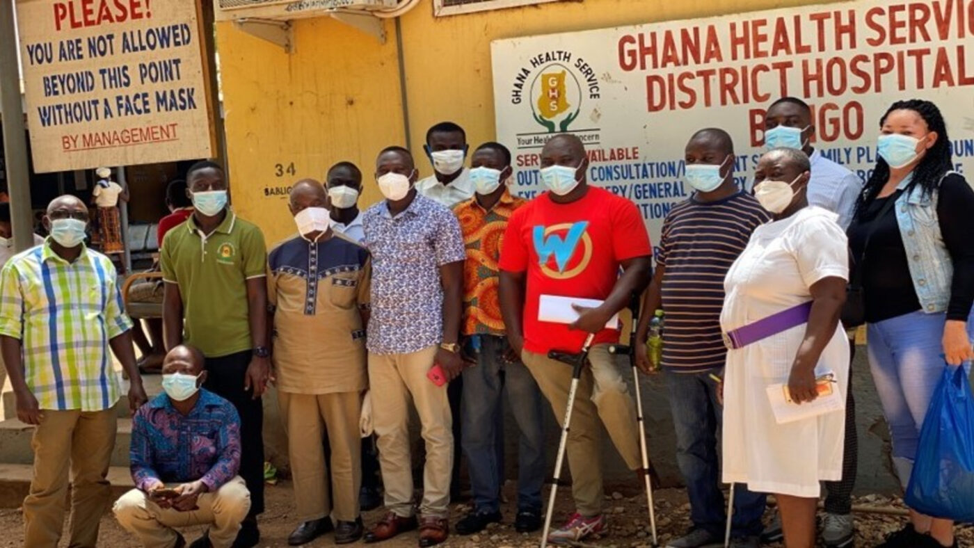 A group of people wearing face masks stand outside a hospital in Bongo, Ghana.