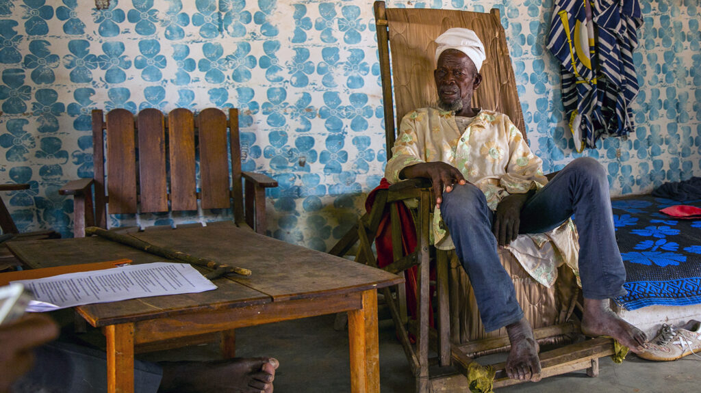 Sonbobia sits on a chair in a colourfully decorated room.