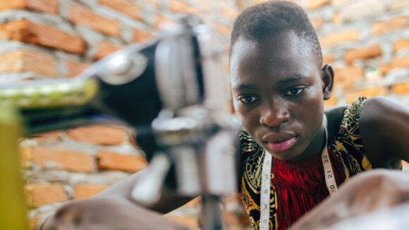 A close-up of a woman using a sewing machine in Uganda.