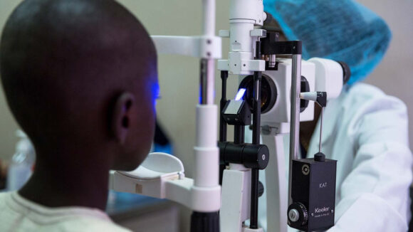 A doctor examines Souleymane's eyes for cataracts