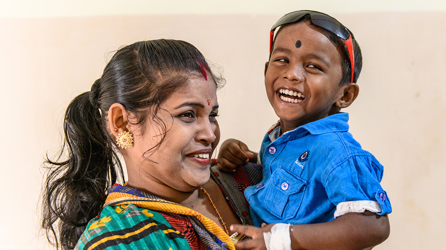 Omm and his mother smile widely after his cataract operation.