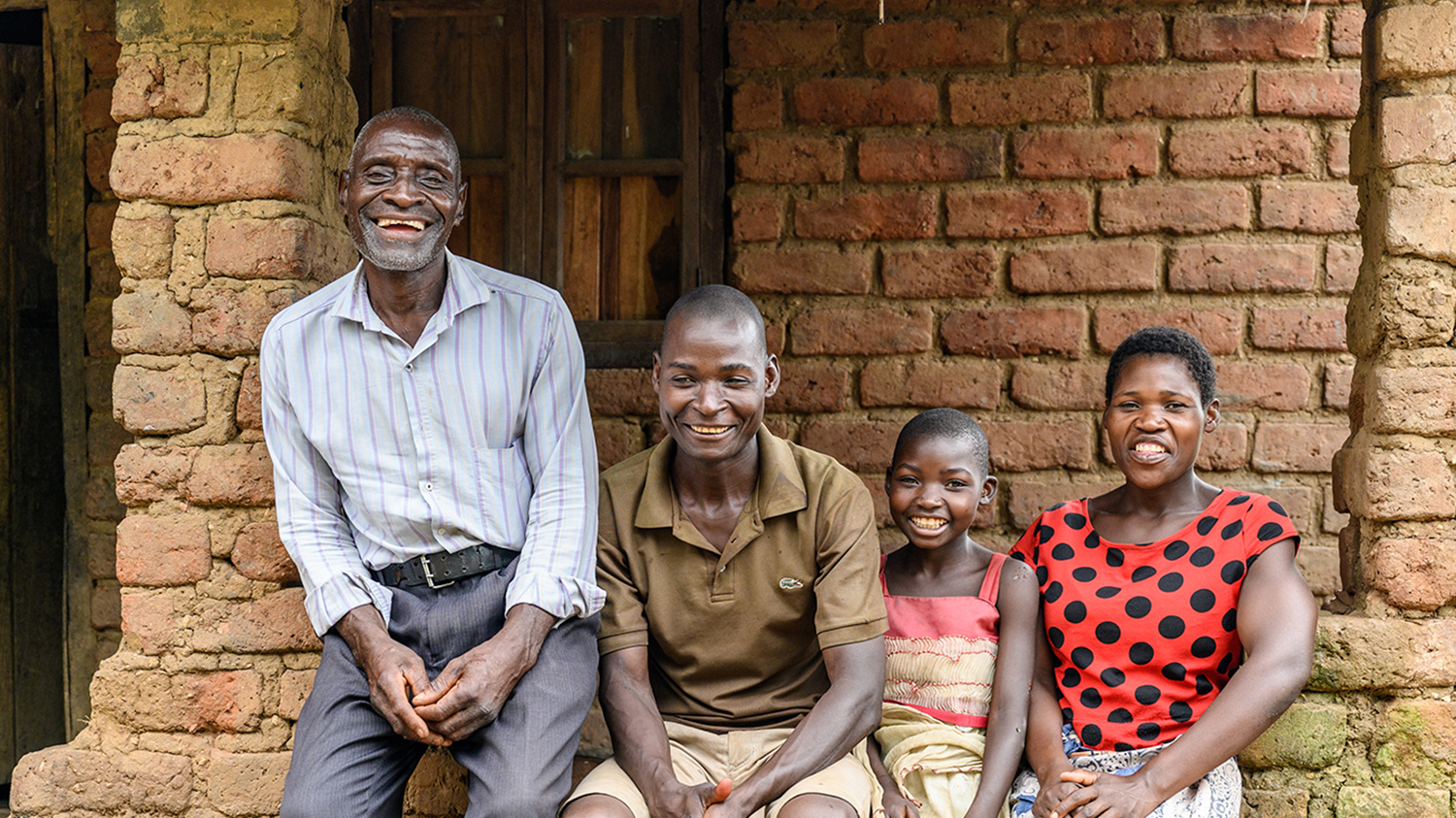 Mary sits with her grandfather and family outside their home after her surgery.