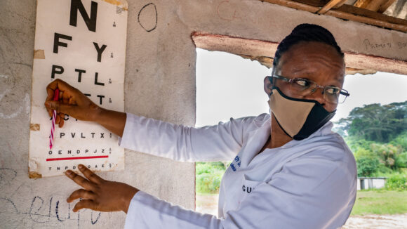 Vision technician Ruth Zeo points to an eye chart during an eye screening