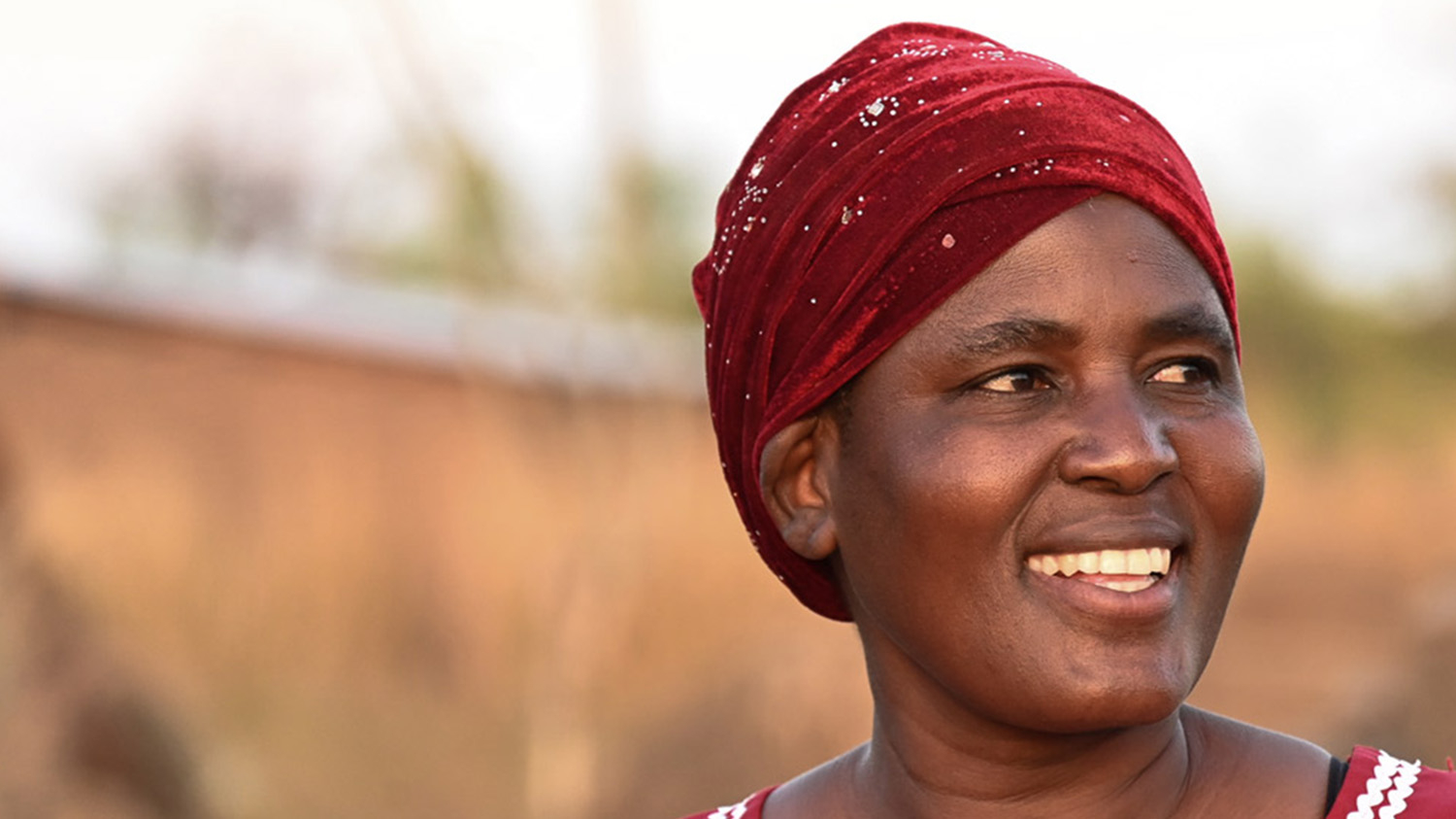Mariam smiles outside her home.