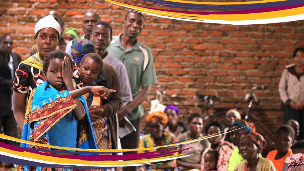 A young girl covers her eye during an eye test at a screening camp in Malawi.