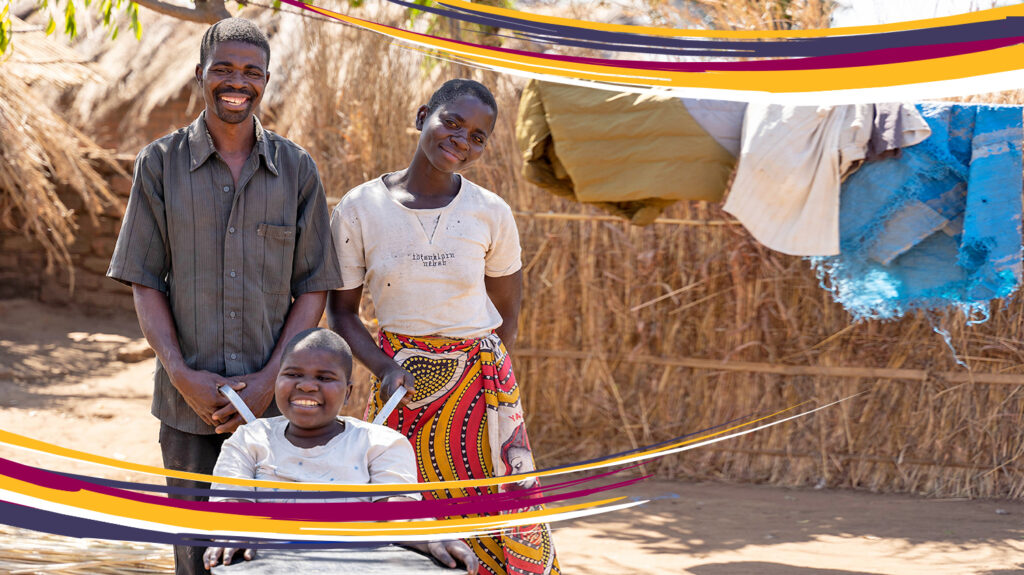 Chukumbutso in Malawi with his wife and son, who's in a wheelchair. They're standing outside and smiling.