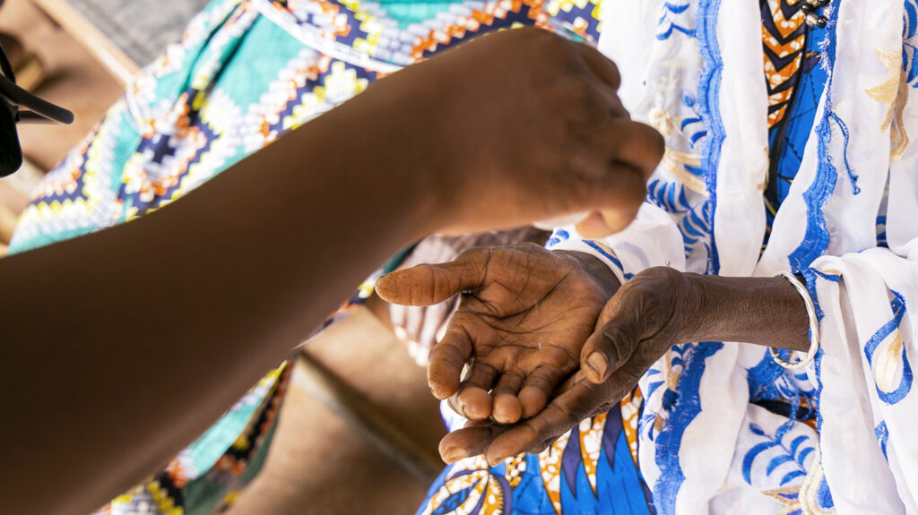 A health worker hands someone some medication.