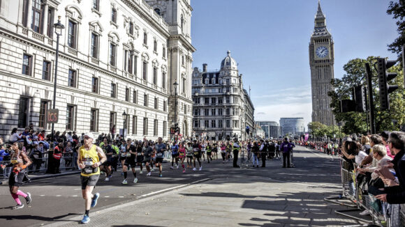 Athletes run down the streets of London with Big Ben in the background.