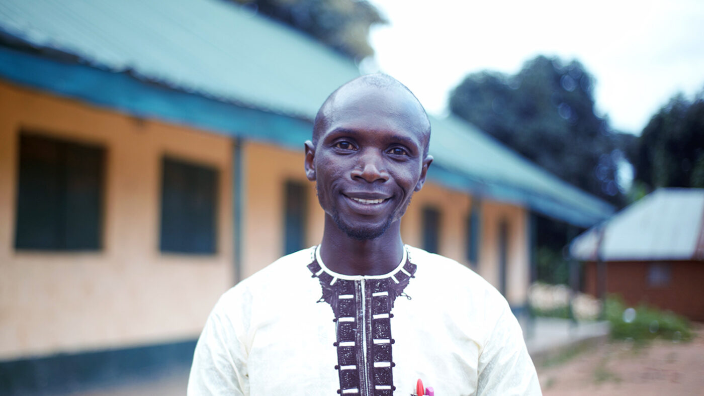 Teacher Zachariah Jacob stands outside his school in Nigeria.
