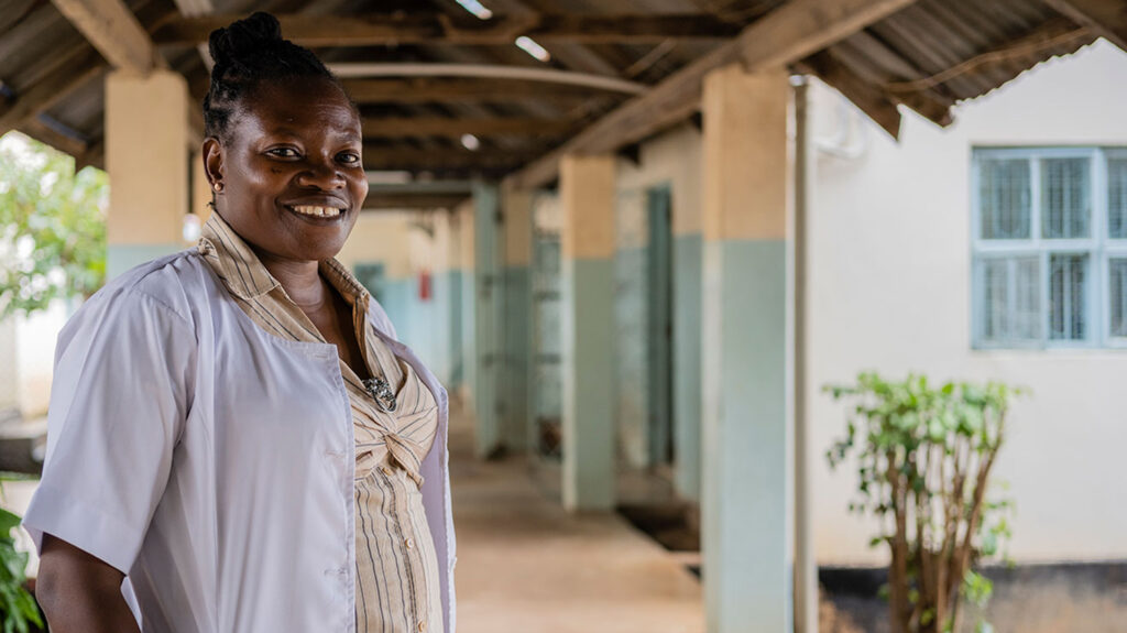 Eye surgeon Upendo smiles while standing outside Singida Referral Hospital.
