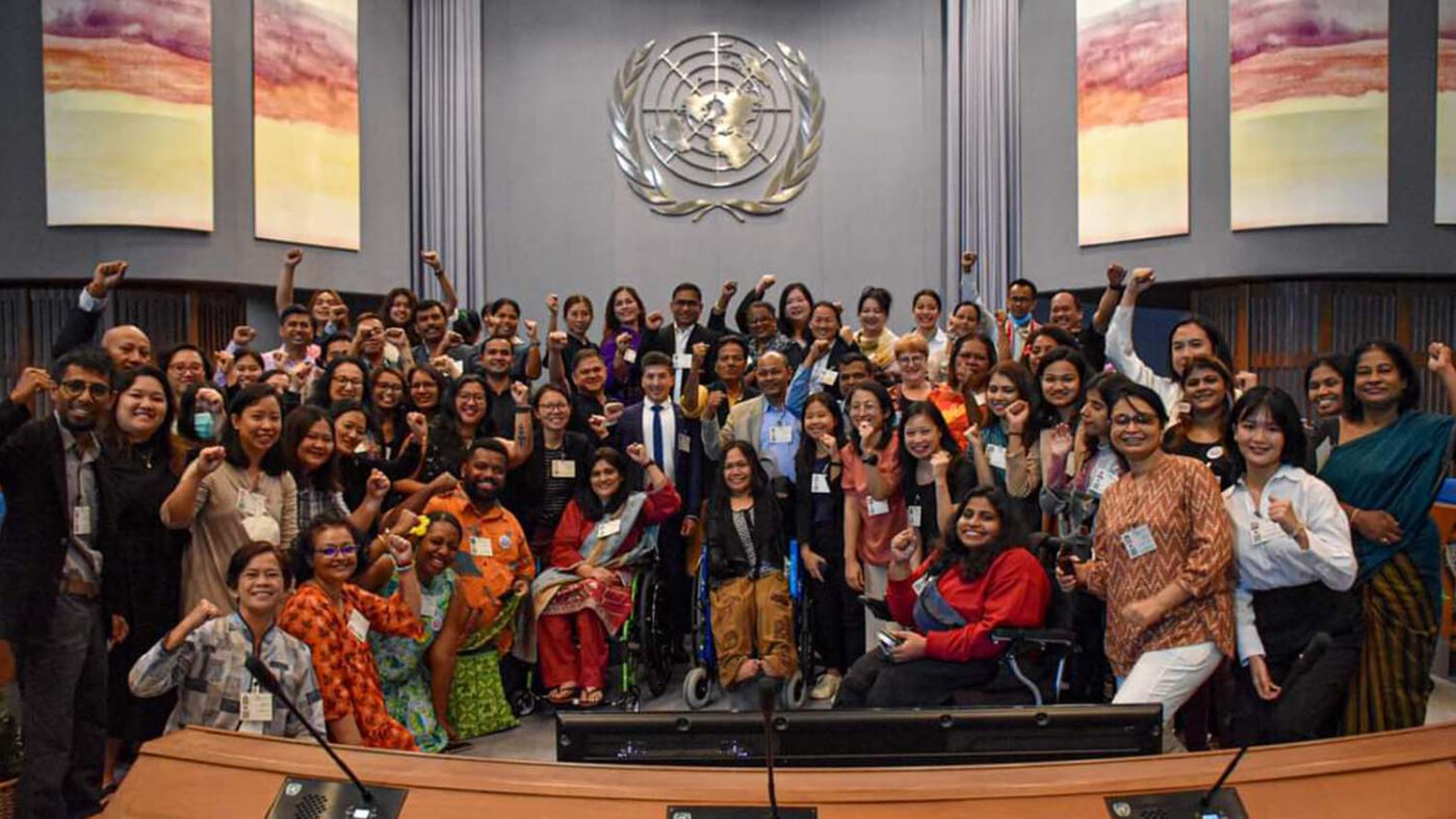 A large group of delegates cheers at the 10th Asia Pacific Forum on Sustainable Development in Bangkok.