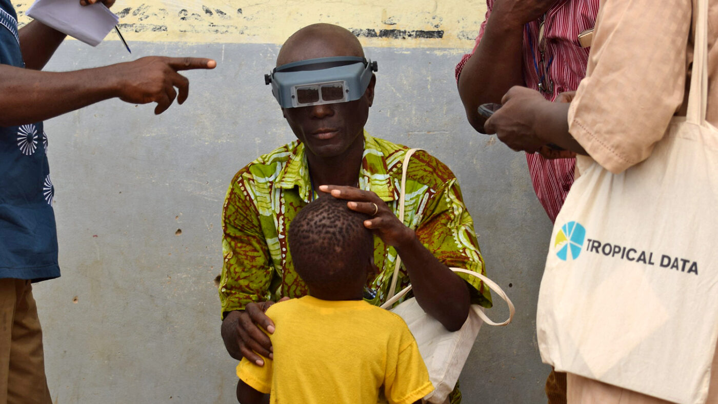 An eye health worker checks a child's eyes during a trachoma training event.