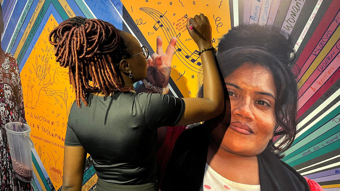A visitor at the Women Deliver conference writes a message on the wall of Sightsavers' stand.