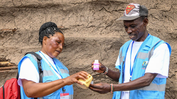 Community drug distributors James and Elizabeth check medication for trachoma in Kenya.